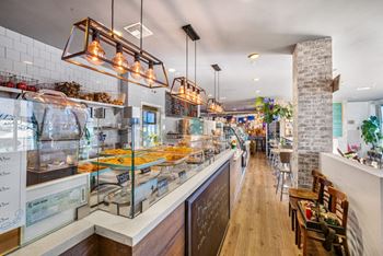 A restaurant with a long counter and a variety of food displayed.